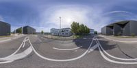 a 360 - lens photo shows the intersection of two streets with three buildings in the background