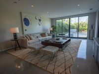 a modern living room has an elegant table in between glass doors and the wall to outside