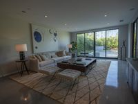 a modern living room has an elegant table in between glass doors and the wall to outside