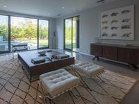 a modern living room has an elegant table in between glass doors and the wall to outside