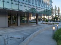 two grey blocks sitting next to a tall building on a sidewalk in front of grass