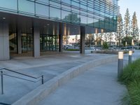 two grey blocks sitting next to a tall building on a sidewalk in front of grass