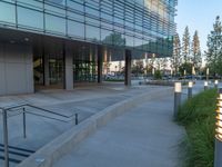 two grey blocks sitting next to a tall building on a sidewalk in front of grass