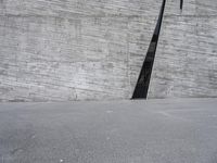 an empty parking lot next to a cement structure with a black door opening into it