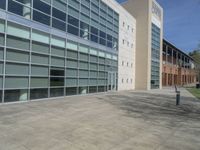 a group of large glass windows sit in front of a brick building and the sky