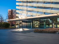 an open courtyard area has green grass, trees, and buildings on the other side