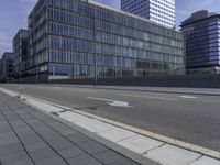 the empty city street in front of a modern office building is shown in this image