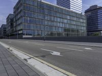 the empty city street in front of a modern office building is shown in this image