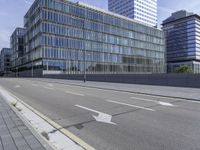 the empty city street in front of a modern office building is shown in this image