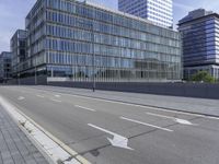 the empty city street in front of a modern office building is shown in this image