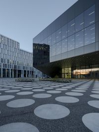 the inside of an office building with large windows and circular spots on a concrete surface