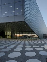 the inside of an office building with large windows and circular spots on a concrete surface