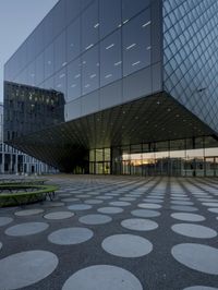 the inside of an office building with large windows and circular spots on a concrete surface