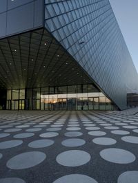 the inside of an office building with large windows and circular spots on a concrete surface