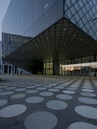 the inside of an office building with large windows and circular spots on a concrete surface