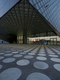 the inside of an office building with large windows and circular spots on a concrete surface