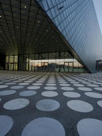 the inside of an office building with large windows and circular spots on a concrete surface