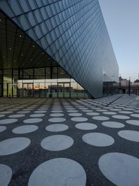 the inside of an office building with large windows and circular spots on a concrete surface