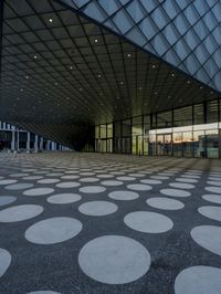 the inside of an office building with large windows and circular spots on a concrete surface