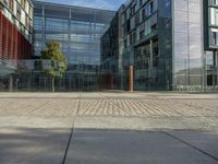 a view of the sidewalk outside a big building on a sunny day with nice windows