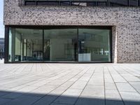 a modern brick building with an external glass door and brick facade next to a sidewalk