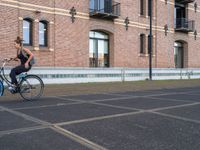 a man is riding a skateboard in the street near some buildings, as if he is going for an urban road