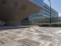 a sidewalk outside with an open space in the foreground that has a building and large mirrored windows