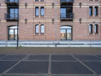 two buildings with windows and a skateboard in front of it on a concrete ground