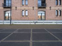 two buildings with windows and a skateboard in front of it on a concrete ground