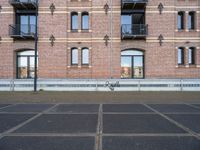 two buildings with windows and a skateboard in front of it on a concrete ground