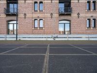 two buildings with windows and a skateboard in front of it on a concrete ground