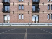 two buildings with windows and a skateboard in front of it on a concrete ground