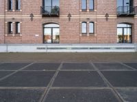 two buildings with windows and a skateboard in front of it on a concrete ground