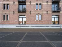 two buildings with windows and a skateboard in front of it on a concrete ground