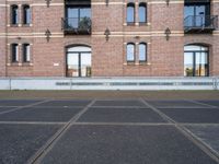 two buildings with windows and a skateboard in front of it on a concrete ground