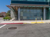 this is a parking lot with a car outside it and a building behind it on the side of the road