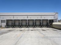 a parking lot with several loading carts and a truck behind it of some sort of structure