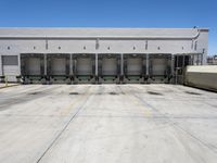 a parking lot with several loading carts and a truck behind it of some sort of structure