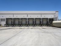 a parking lot with several loading carts and a truck behind it of some sort of structure