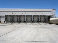 a parking lot with several loading carts and a truck behind it of some sort of structure