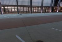 a large building with several glass windows and some lights above it with one light on in the middle