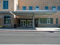 the front of a building with a building awning in the middle and a sidewalk outside of the building