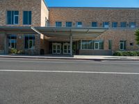 the front of a building with a building awning in the middle and a sidewalk outside of the building