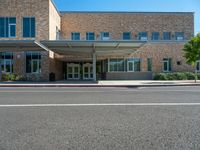 the front of a building with a building awning in the middle and a sidewalk outside of the building