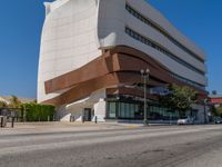 this is a building with a very large building behind it and cars driving on the street below