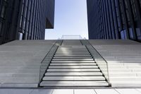 the stairs going up to some very tall buildings in a city of glass and white