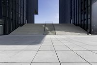 the stairs going up to some very tall buildings in a city of glass and white