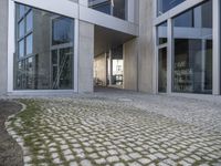 an entry way into the building with large glass doors to the outside and another courtyard on the other side