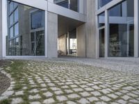 an entry way into the building with large glass doors to the outside and another courtyard on the other side