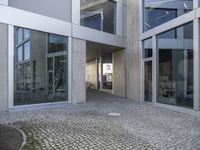 an entry way into the building with large glass doors to the outside and another courtyard on the other side